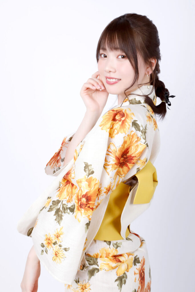 石川澪のヌードグラビア、青いドレスでベッドに座りおっぱいを強調したセクシーなポーズ
